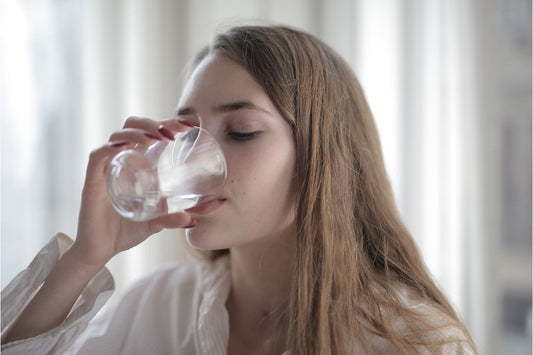 Woman drinking a glass of water at home