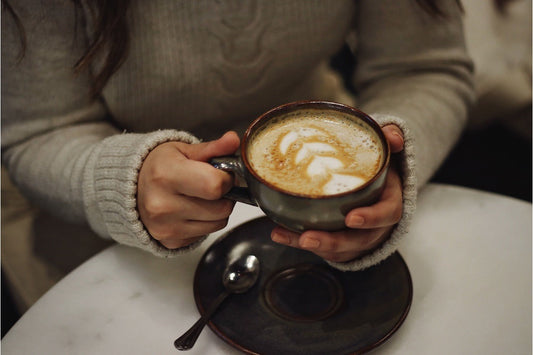 Hands holding a cup of latte