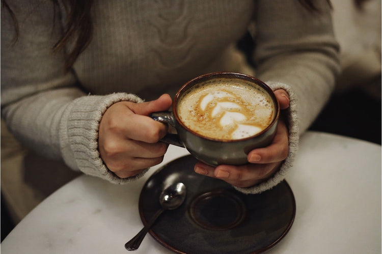 Hands holding a cup of latte