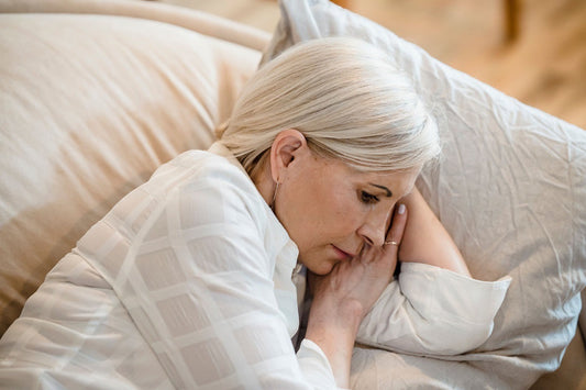 Woman lying awake in daytime, showing the unrefreshing sleep and fatigue that people with fibromyalgia report alongside widespread pain